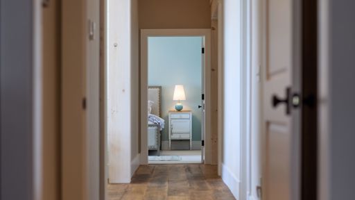 View of bedroom at the end of a hallway